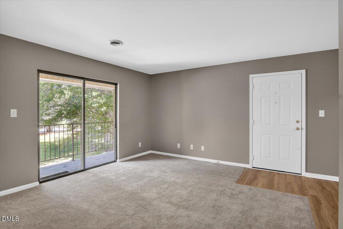 1630 Oxford Road, Unit F Henderson, NC 27536 - Photo 7 of 33 a view of an empty room with wooden floor and a window