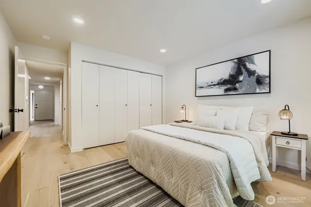 a bedroom with a bed and a painting on the wall