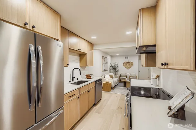 a kitchen with stainless steel appliances granite countertop a refrigerator and a sink