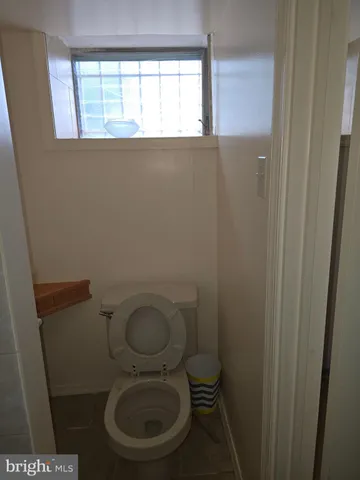 a white toilet sitting in a bathroom next to a window