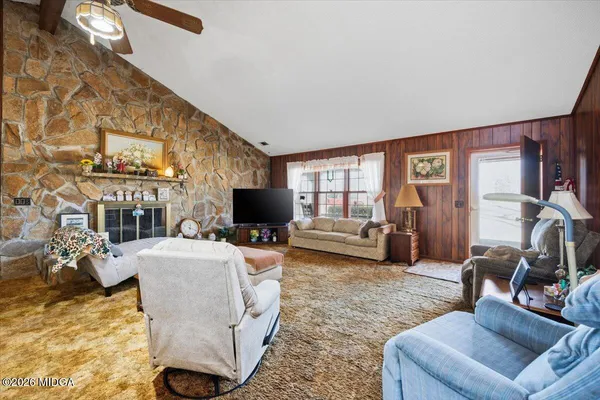 a living room with furniture and a floor to ceiling window