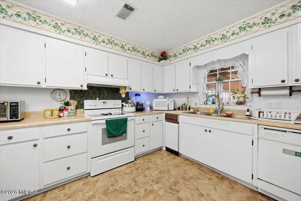 a bathroom with a sink a toilet and shower curtain