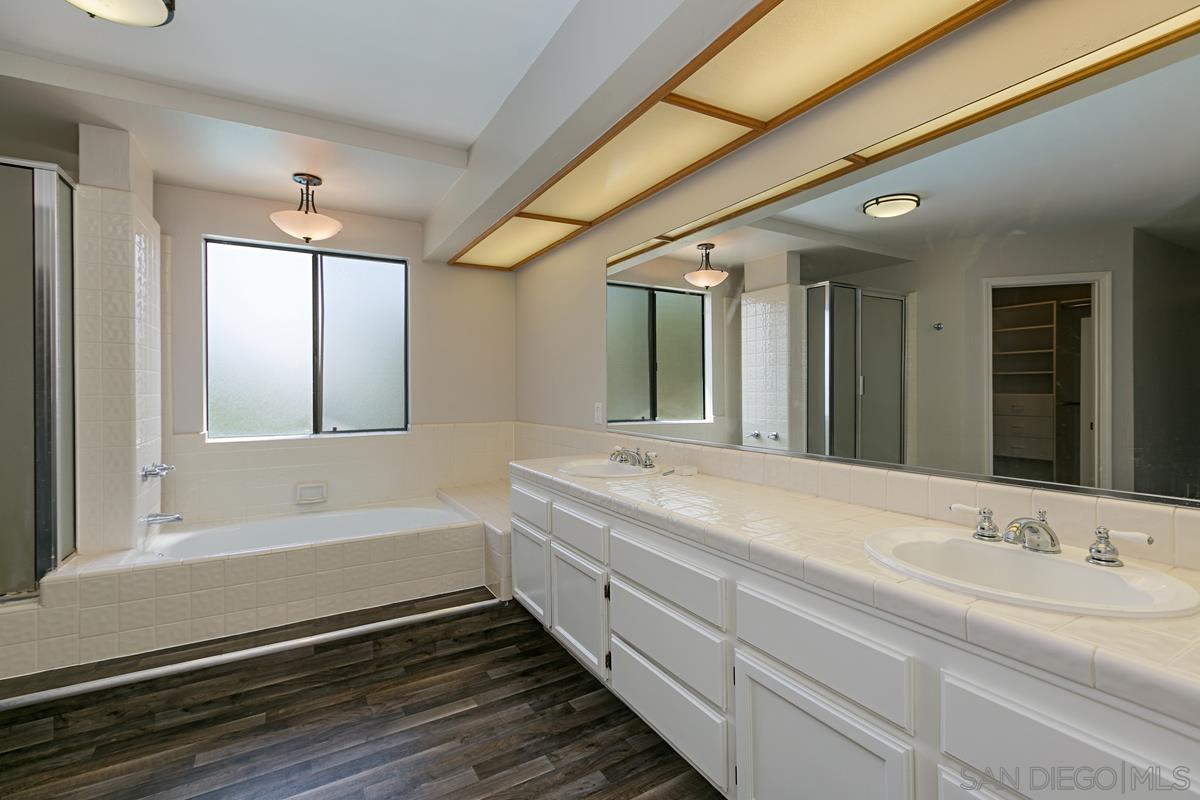 4031 Grayson Drive San Diego, CA 92130 - Photo 16 of 27 a bathroom with a double vanity sink and mirror with bathtub
