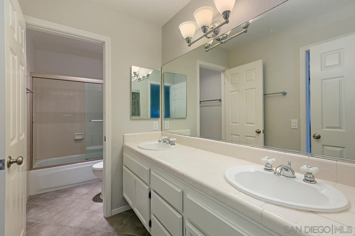 4031 Grayson Drive San Diego, CA 92130 - Photo 22 of 27 a bathroom with a double vanity sink mirror and shower
