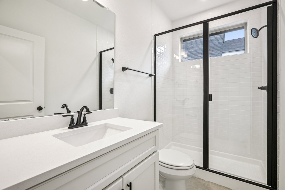 581 Treadwell Lane Kyle, TX 78640 - Photo 13 of 27 a bathroom with a sink a toilet a shower and a mirror