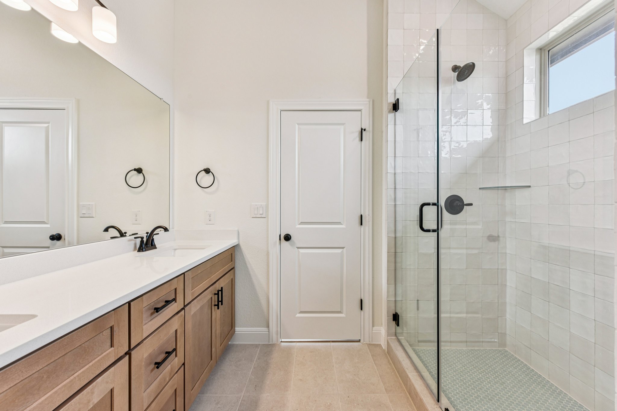 581 Treadwell Lane Kyle, TX 78640 - Photo 15 of 26 a spacious bathroom with a double vanity sink a mirror and shower