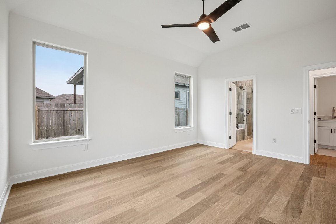 581 Treadwell Lane Kyle, TX 78640 - Photo 19 of 27 a view of an empty room with wooden floor and a window