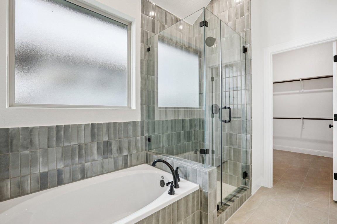 581 Treadwell Lane Kyle, TX 78640 - Photo 22 of 27 a bathroom with a bathtub and a shower