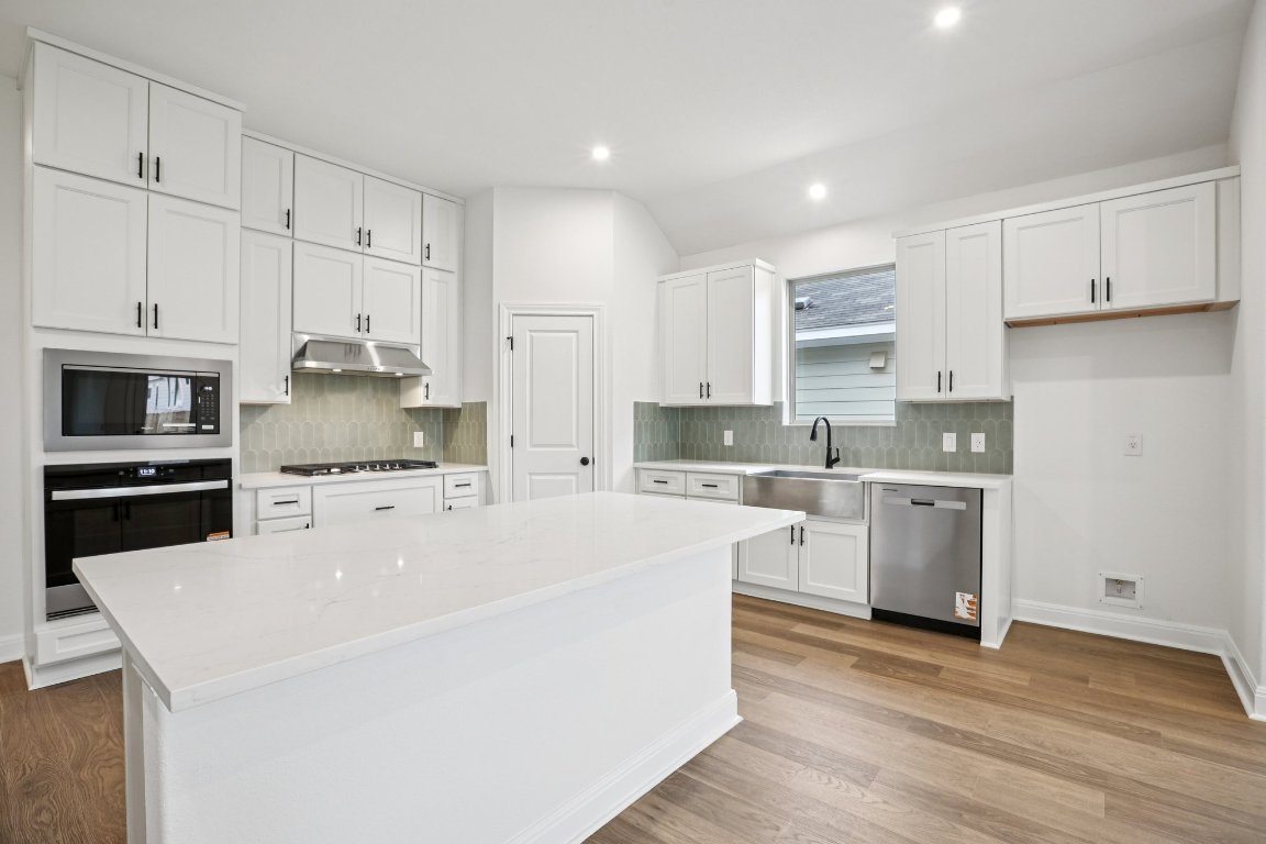 581 Treadwell Lane Kyle, TX 78640 - Photo 3 of 27 a kitchen with cabinets appliances wooden floor and a window