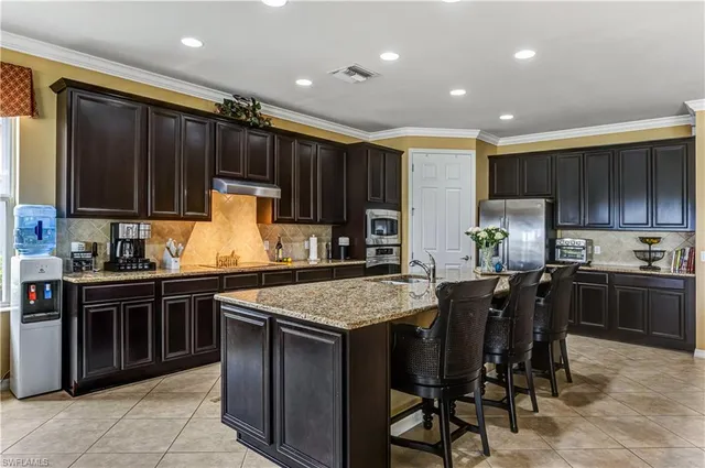 a kitchen with stainless steel appliances granite countertop a sink and a refrigerator