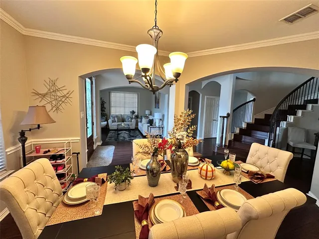 a living room with furniture a chandelier and a flat screen tv