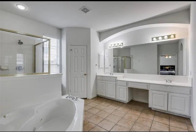 a bathroom with a tub sink and mirror