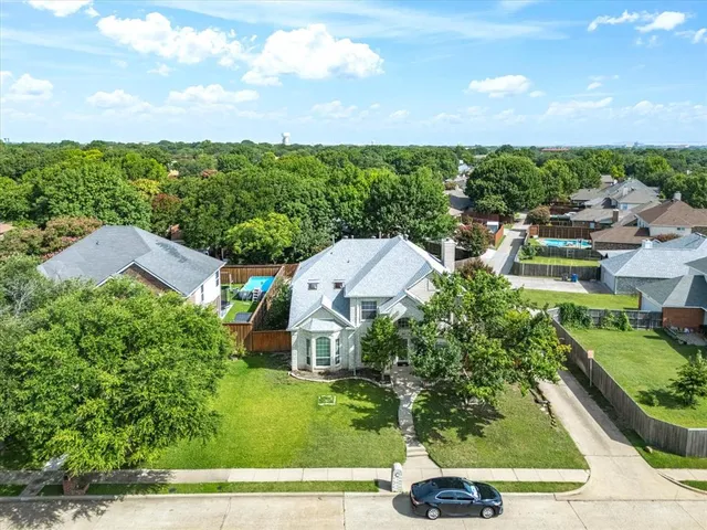 an aerial view of residential houses with outdoor space and trees