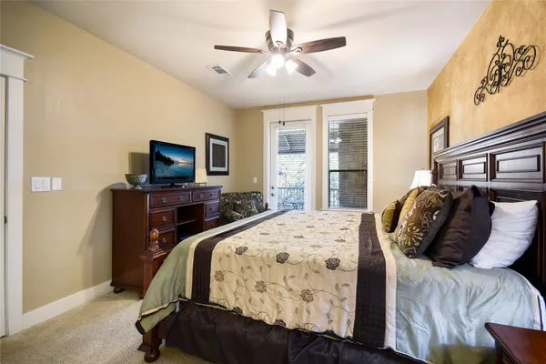 a bedroom with a bed flat screen tv and a window