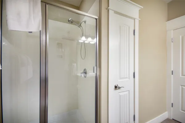 a bathroom with a glass shower door and a mirror