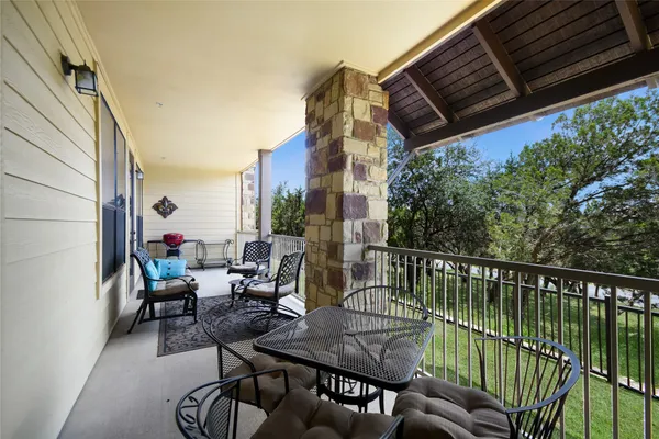 a view of a balcony with chairs and wooden floor