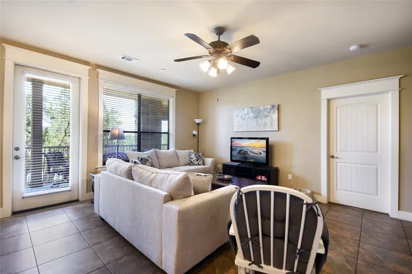 a living room with furniture two window and a flat screen tv