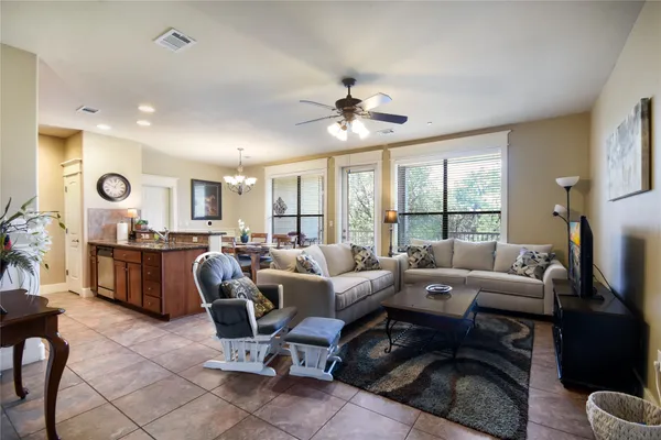 a living room with furniture a large window and a chandelier