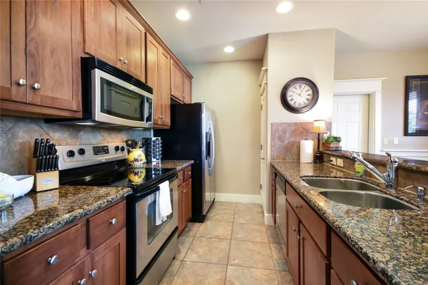 a kitchen with stainless steel appliances granite countertop a sink stove and refrigerator