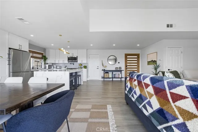 a living room with stainless steel appliances furniture and a kitchen view