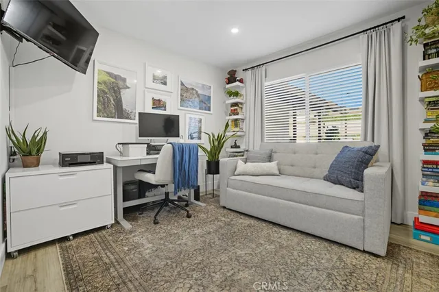 a living room with furniture a flat screen tv and a window