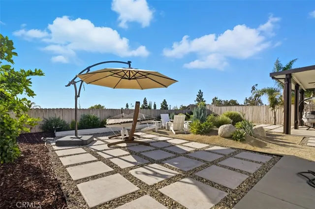 a view of a patio with a table and chairs under an umbrella