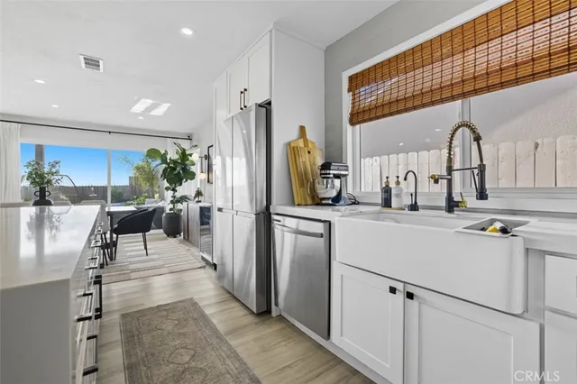 a kitchen with stainless steel appliances kitchen island granite countertop a refrigerator and a sink