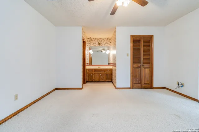 an empty room with chandelier fan