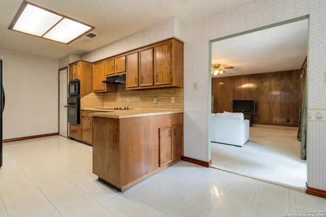 a view of a kitchen with a sink and a refrigerator