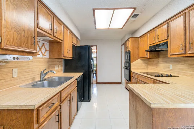 a kitchen with stainless steel appliances granite countertop a sink and a refrigerator