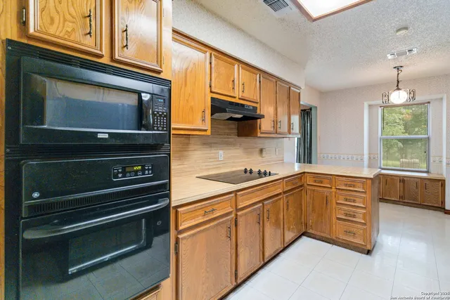 a kitchen with granite countertop cabinets stainless steel appliances and a window