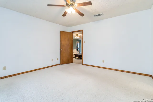 an empty room with closet and a chandelier fan