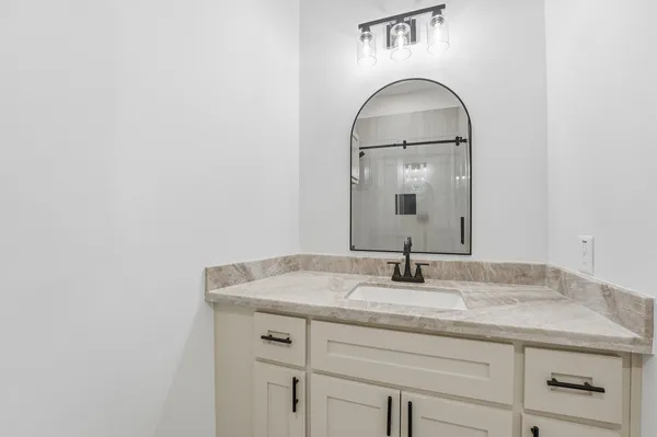 a bathroom with a granite countertop sink and a mirror