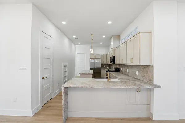 a kitchen with kitchen island a sink stainless steel appliances and white cabinets
