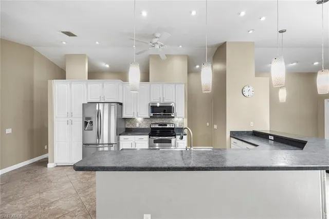 a kitchen with stainless steel appliances granite countertop a refrigerator and a sink