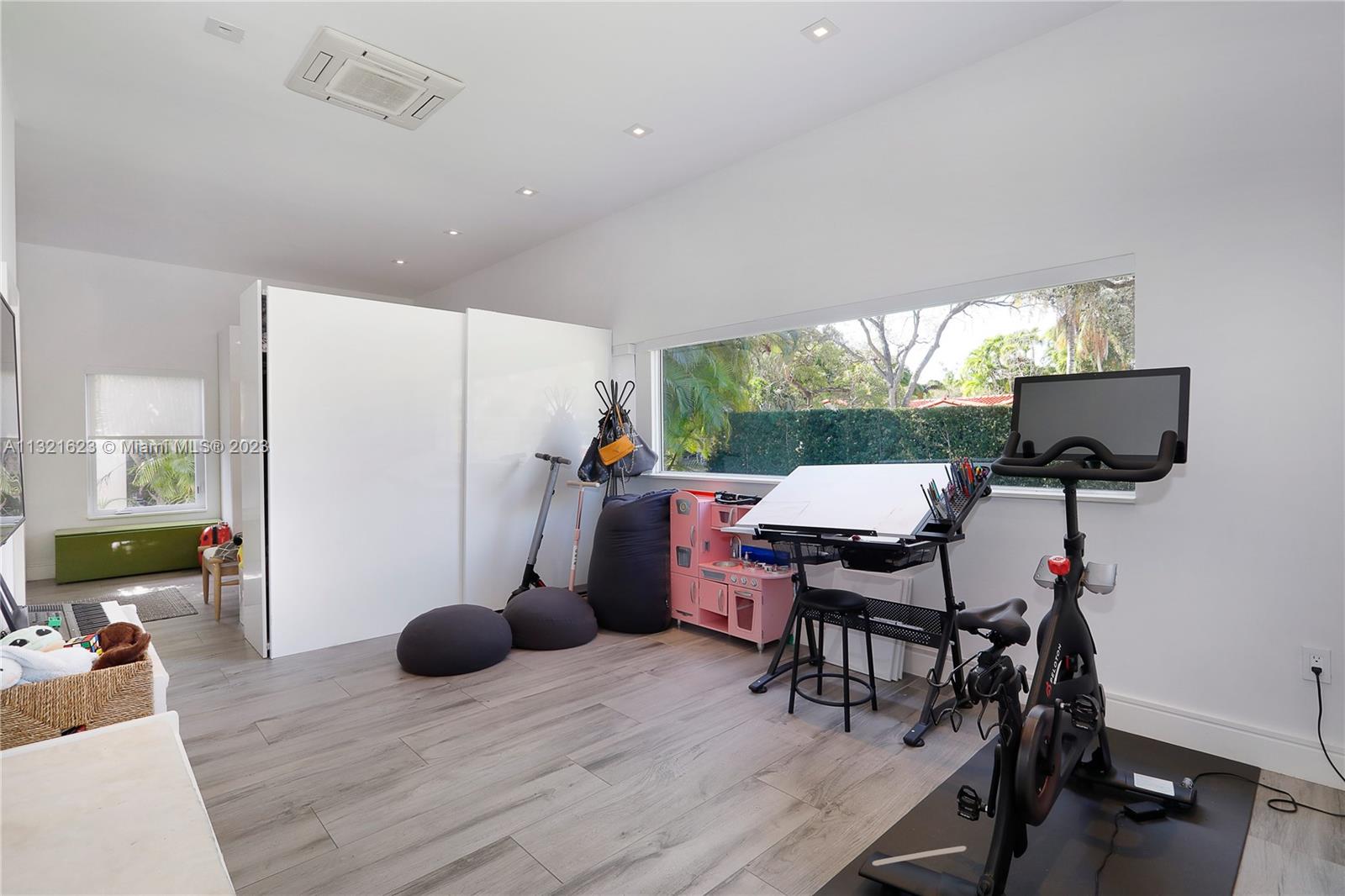 425 Glenridge Road Key Biscayne, FL 33149 - Photo 25 of 37 a living room with furniture a flat screen tv and a floor to ceiling window
