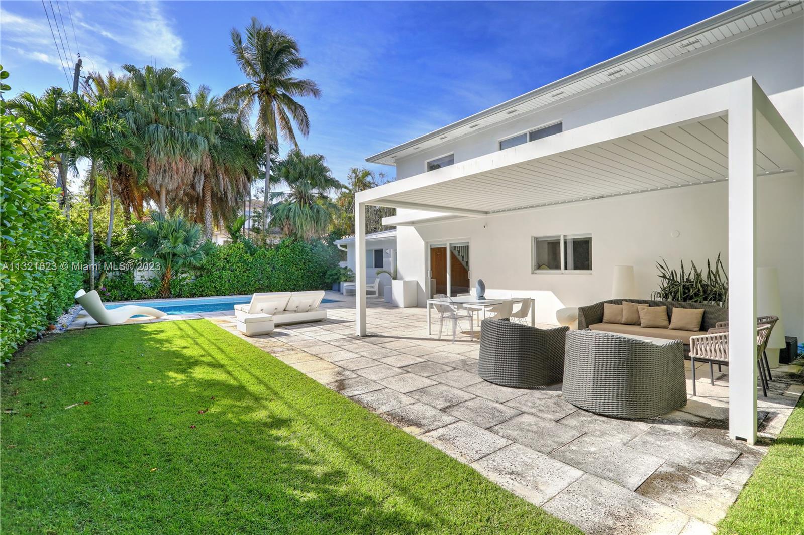 425 Glenridge Road Key Biscayne, FL 33149 - Photo 33 of 37 a view of a patio with table and chairs potted plants and palm tree