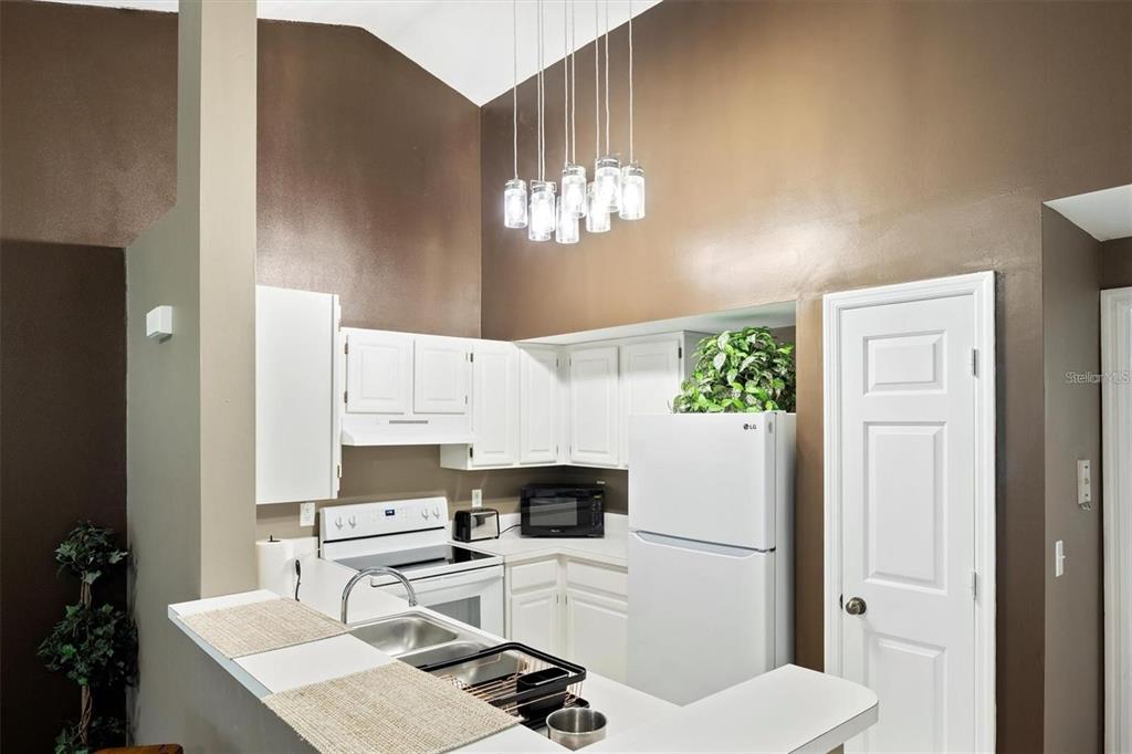 10000 Southwest 52nd Avenue, Unit EE 183 Gainesville, FL 32608 - Photo 8 of 16 a white kitchen with sink a refrigerator and a stove