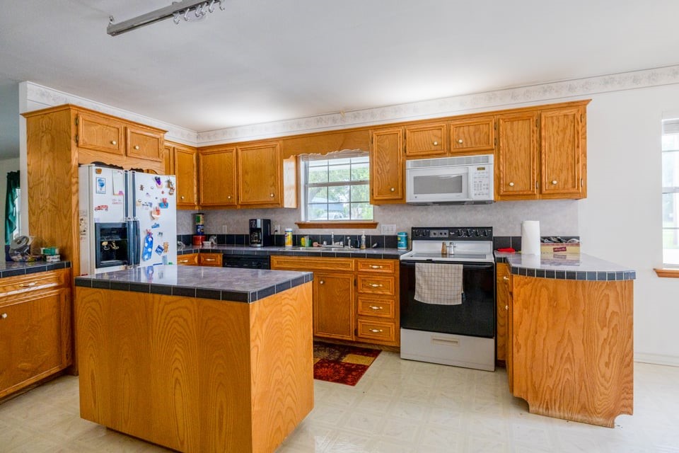 483 Riverside Drive Palacios, TX 77465 - Photo 9 of 41 a kitchen with stainless steel appliances granite countertop a stove a sink a refrigerator and blue cabinets