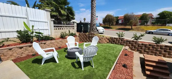 a view of a chairs and table in backyard of the house