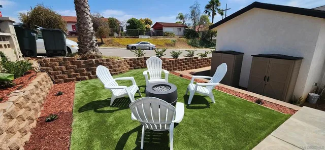 a view of an chairs and table in backyard