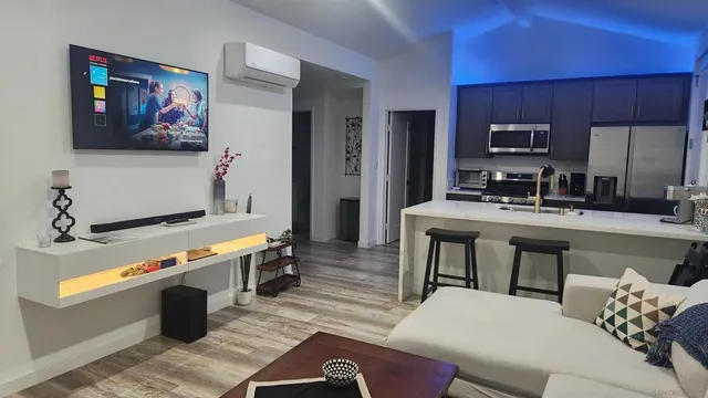 a room with furniture a flat screen tv and a sink