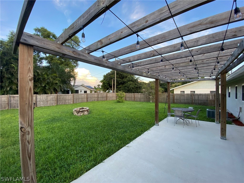 19157 Coconut Road Fort Myers, FL 33967 - Photo 6 of 26 a view of a backyard with table and chairs under an umbrella
