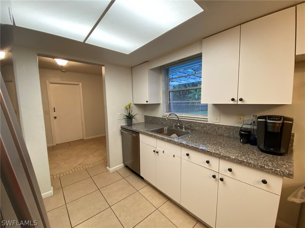 19157 Coconut Road Fort Myers, FL 33967 - Photo 7 of 26 a kitchen with granite countertop a sink a stove and cabinets