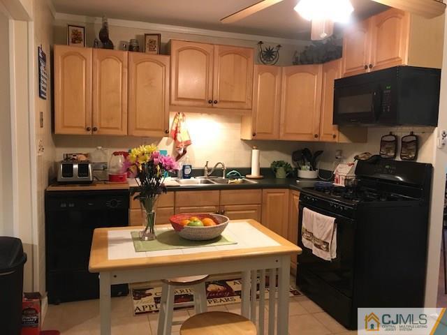 35 Caldwell Road Edison, NJ 08817 - Photo 4 of 16 a kitchen with a sink a microwave a refrigerator and cabinets