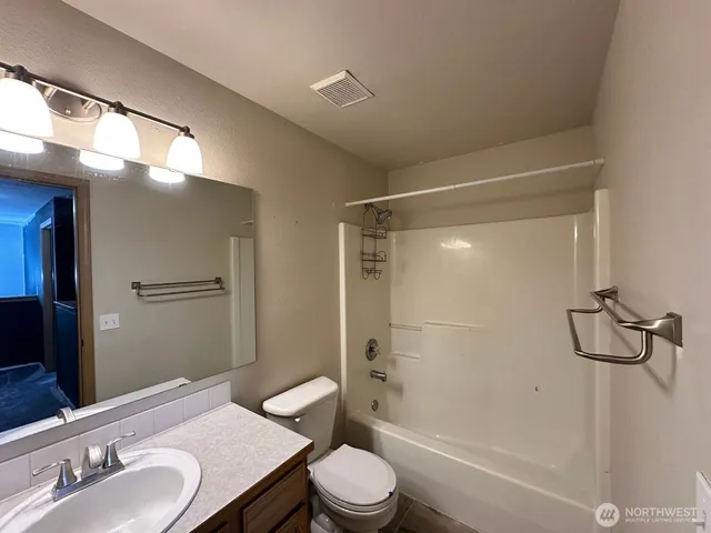 a bathroom with a granite countertop sink toilet and shower
