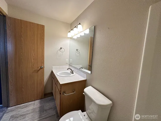 a bathroom with a toilet sink and mirror
