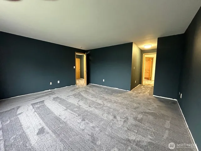a view of a livingroom with wooden floor and a bathroom