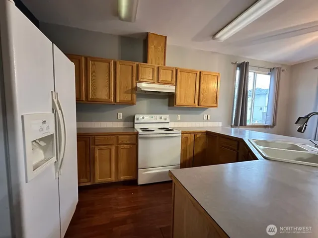 a kitchen with stainless steel appliances granite countertop a sink a stove and a refrigerator