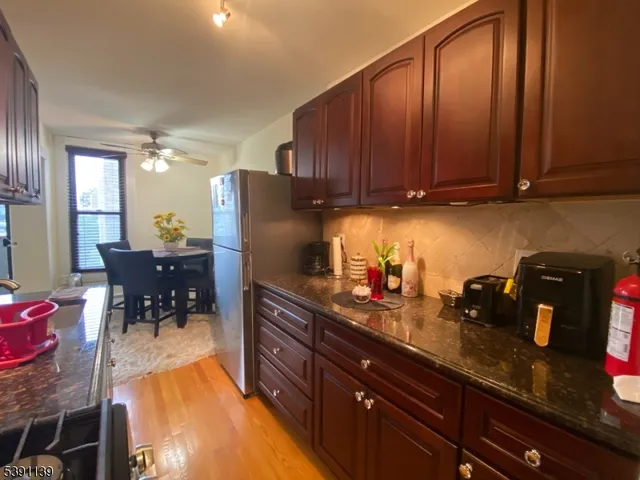 a kitchen with granite countertop wooden cabinets a table and chairs